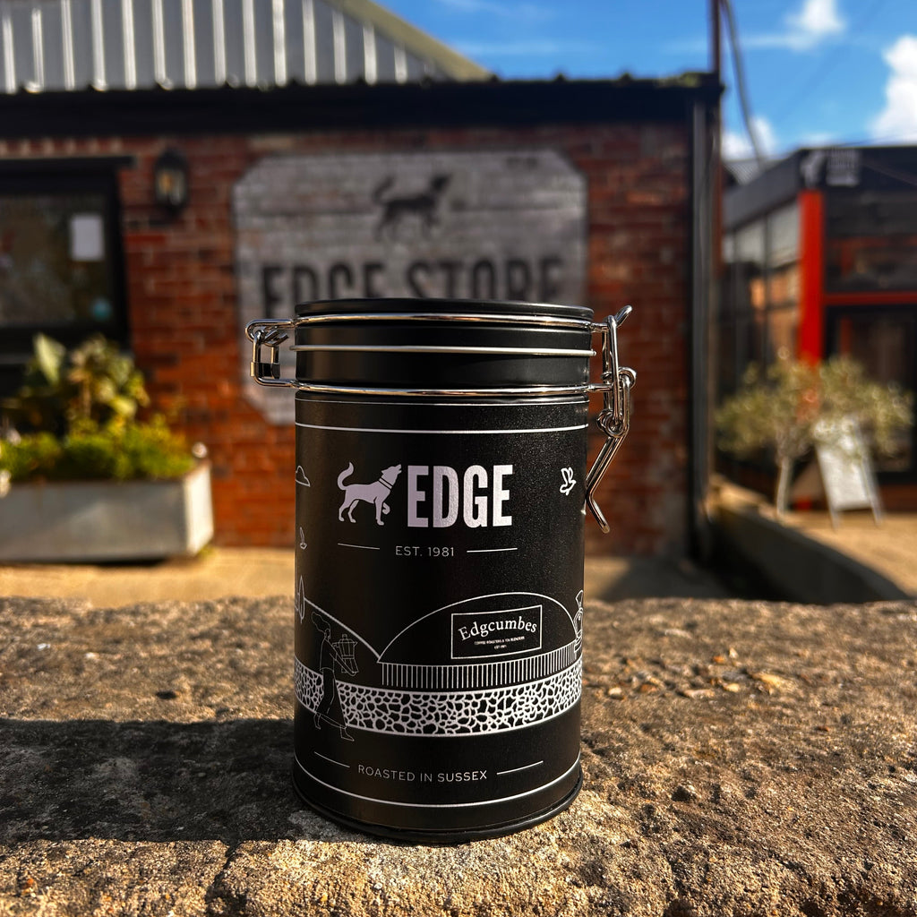 A black metal Coffee Refill Tin with a silver clasp lid and white ...